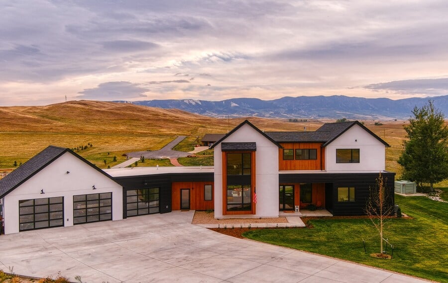 modern custom home exterior in wyoming with several windows and natural wood accents